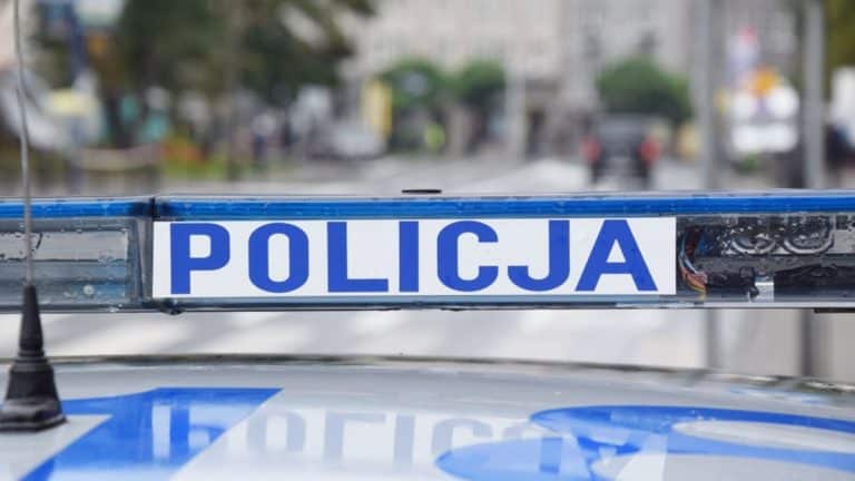 Widok policyjnej blokady na drodze podczas kontroli kierowcy motoroweru w mieście.