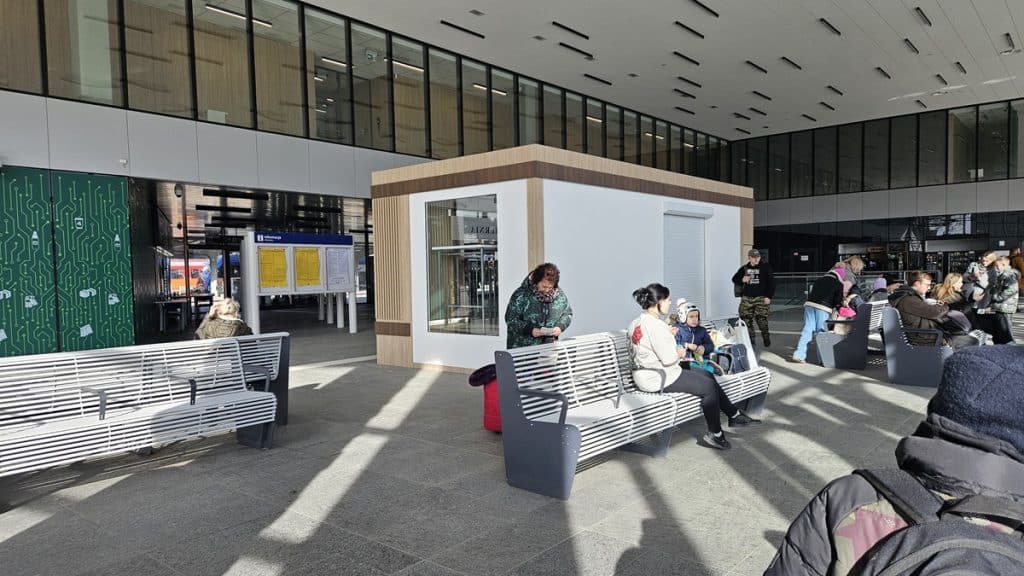 Nowy punkt handlowy w holu dworca Olsztyn Gł&oacute;wny, z ludźmi siedzącymi na ławkach i korzystającymi z usług.