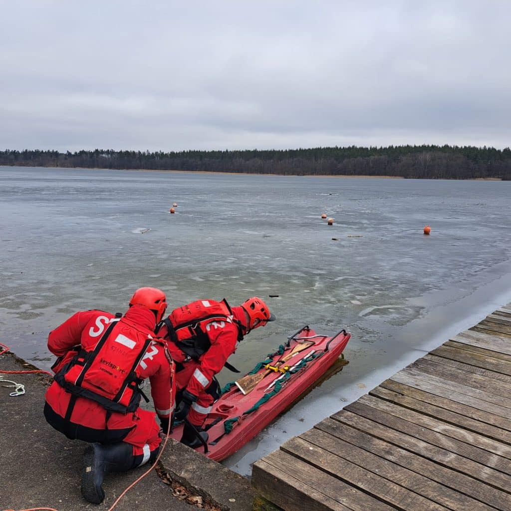Ratownicy wyciągają psa z zamarzniętego jeziora podczas akcji ratunkowej.