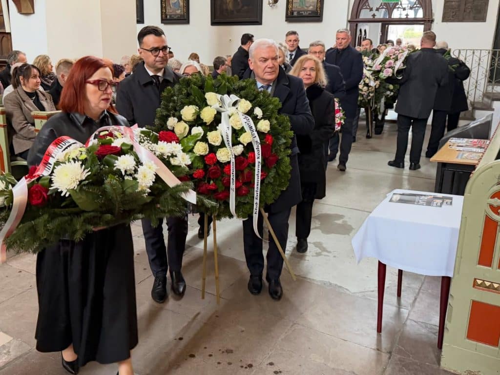 Uroczystości pogrzebowe Eleonory Protas w kościele w Lidzbarku Warmińskim, uczestnicy składają kwiaty.