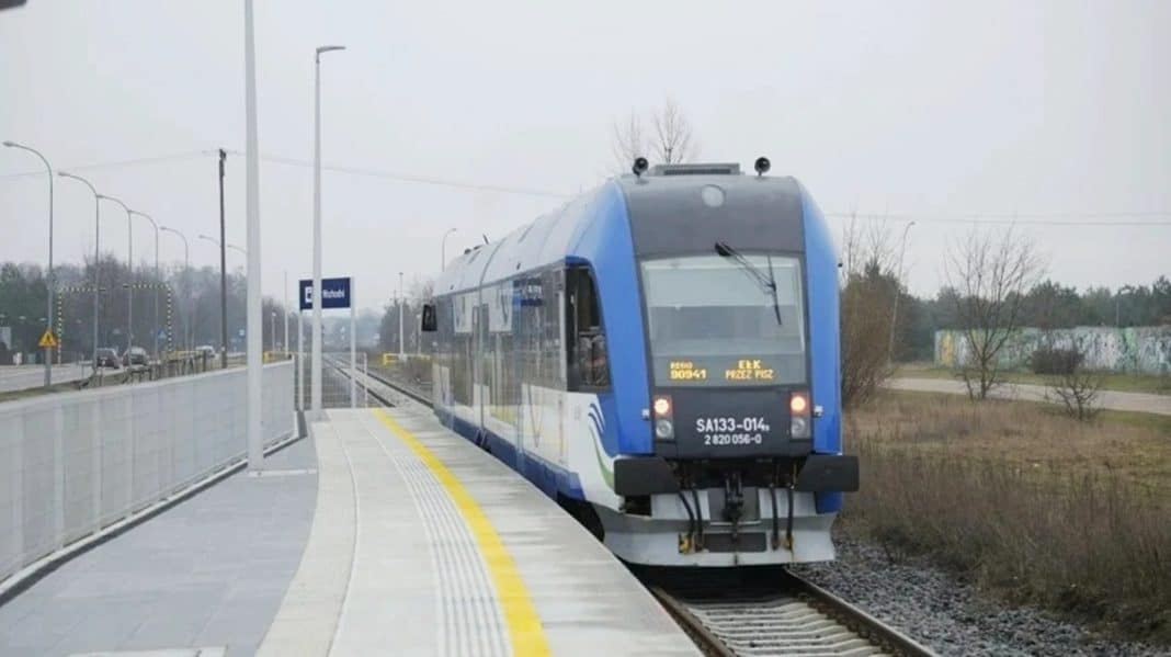 Nowoczesny pociąg elektryczny na nowo wybudowanej stacji kolejowej.