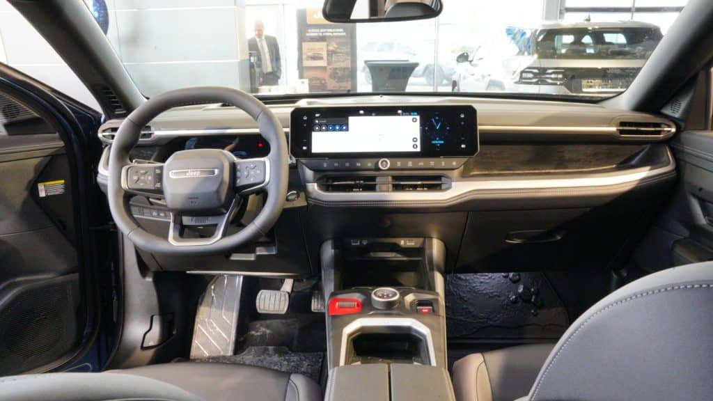 Wnętrze nowego Jeepa Compassa z dużym ekranem dotykowym i nowoczesnym wykończeniem.