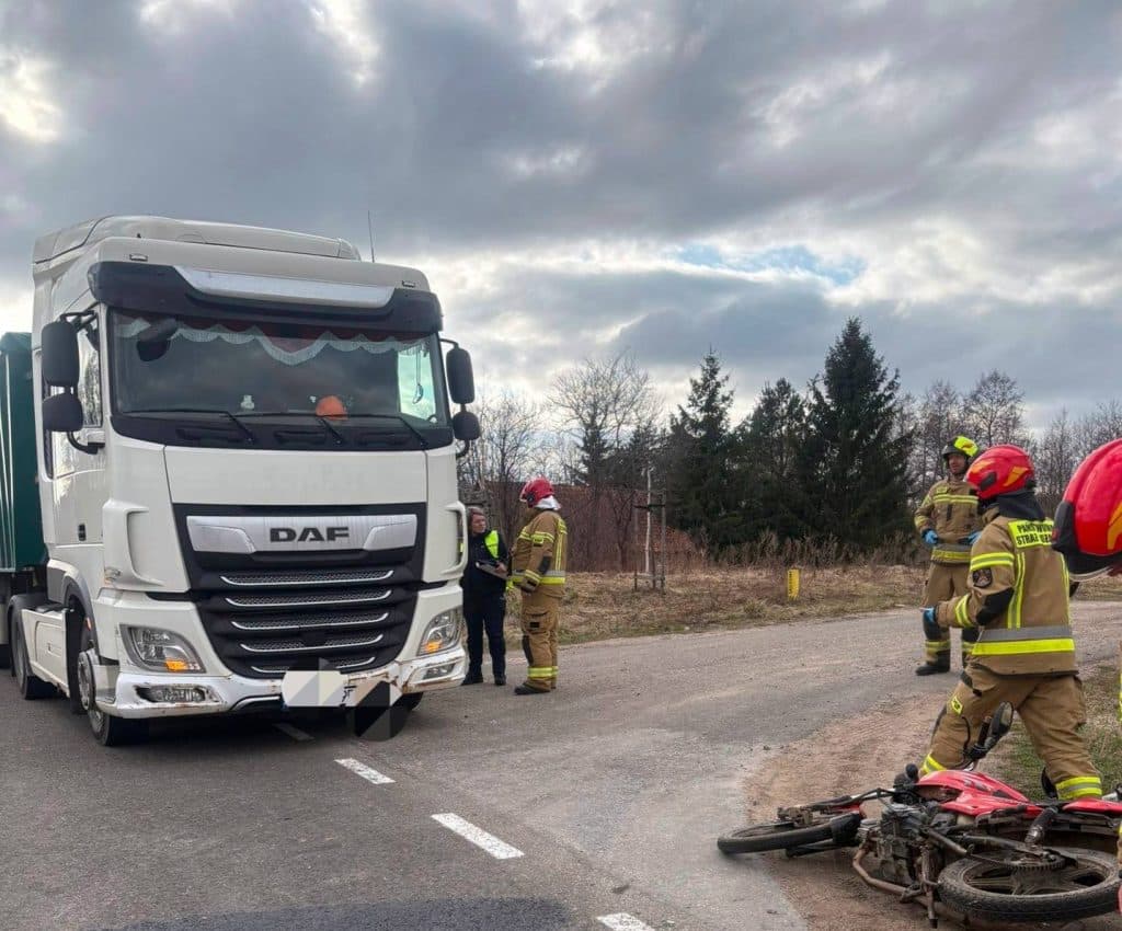 Ciężar&oacute;wka i motorowerzysta na drodze, na miejscu służby ratunkowe, wypadek w miejscowości Pluty.