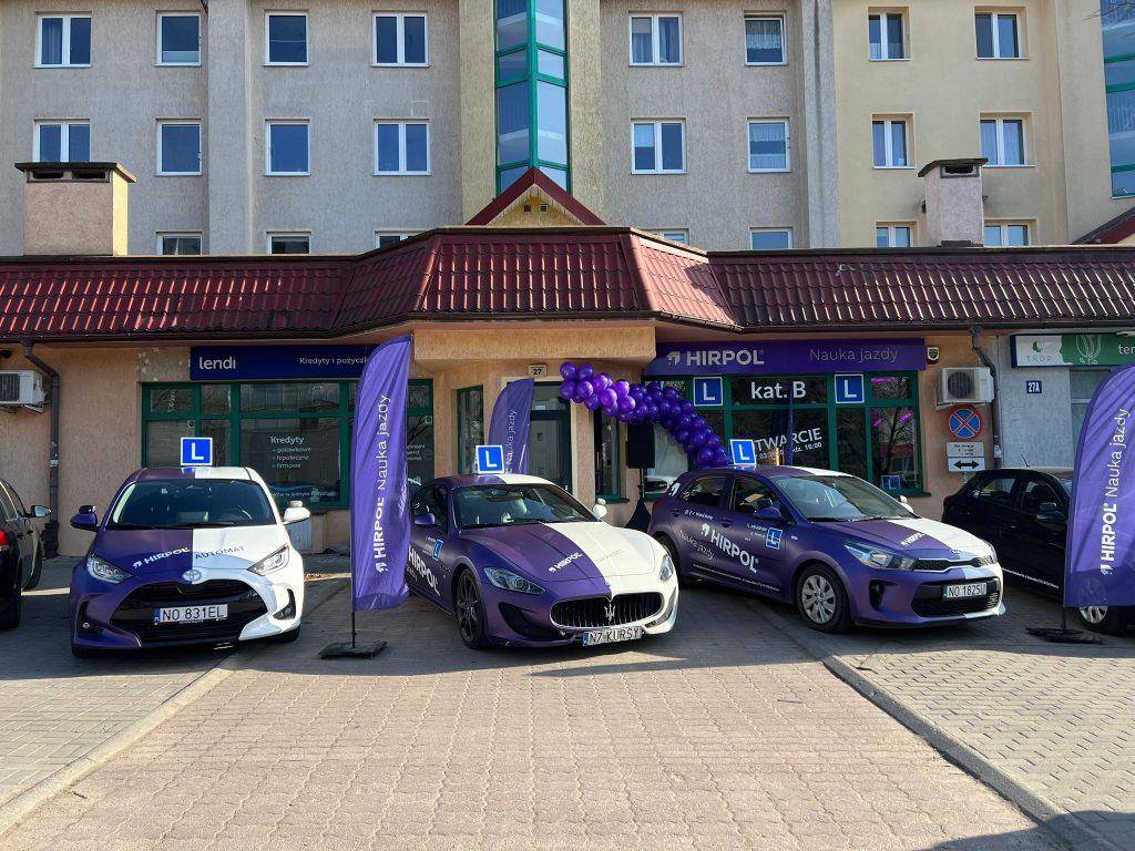 Nowy punkt szkoły jazdy Hirpol na Jarotach z samochodami i balonami przed wejściem.