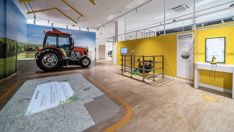 Wewnątrz interaktywnego centrum nauki z traktorami i ekranami edukacyjnymi.