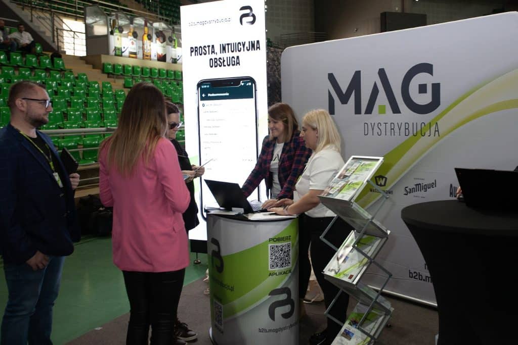 Stoiska targowe i uczestnicy podczas wydarzenia w hali widowiskowo-sportowej Urania.