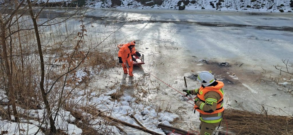 Ratownicy wyciągają mężczyznę z zamarzniętej rzeki Wałsza podczas akcji ratunkowej.