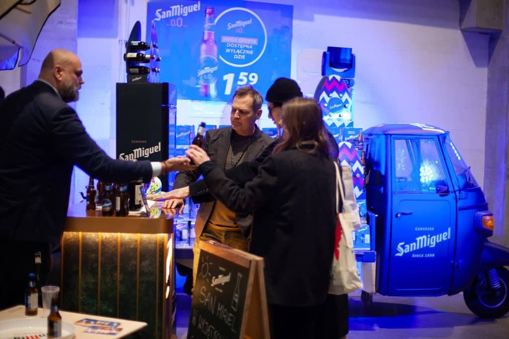 Uczestnicy targ&oacute;w biznesowych w Gdańsku rozmawiają przy stoisku z napojami San Miguel.