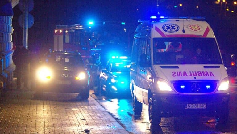 Wypadek na przejściu dla pieszych w Iławie, na miejscu służby ratunkowe, w tle pojazdy z włączonymi światłami.