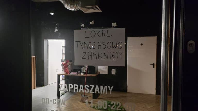 Widok zamkniętej restauracji w centrum Olsztyna z informacją na drzwiach o wstrzymaniu działalności.