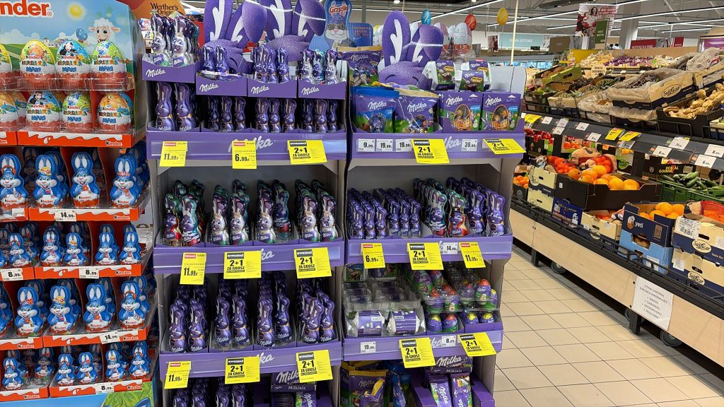Stojak z czekoladowymi jajkami i wielkanocnymi słodyczami w sklepie spożywczym.