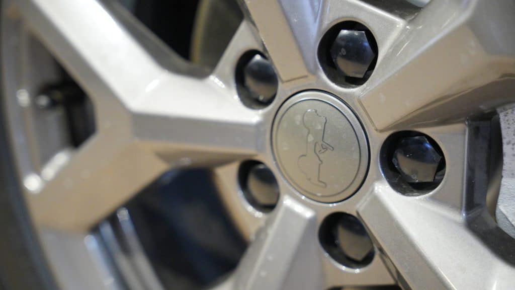 Zbliżenie na felgę samochodu Jeep, widoczne logo marki na środku.