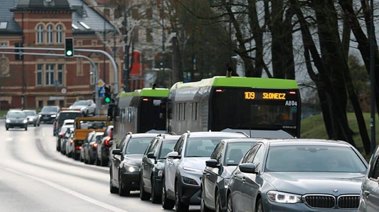 Korek samochod&oacute;w na ulicy w Olsztynie, w tle autobus miejski.