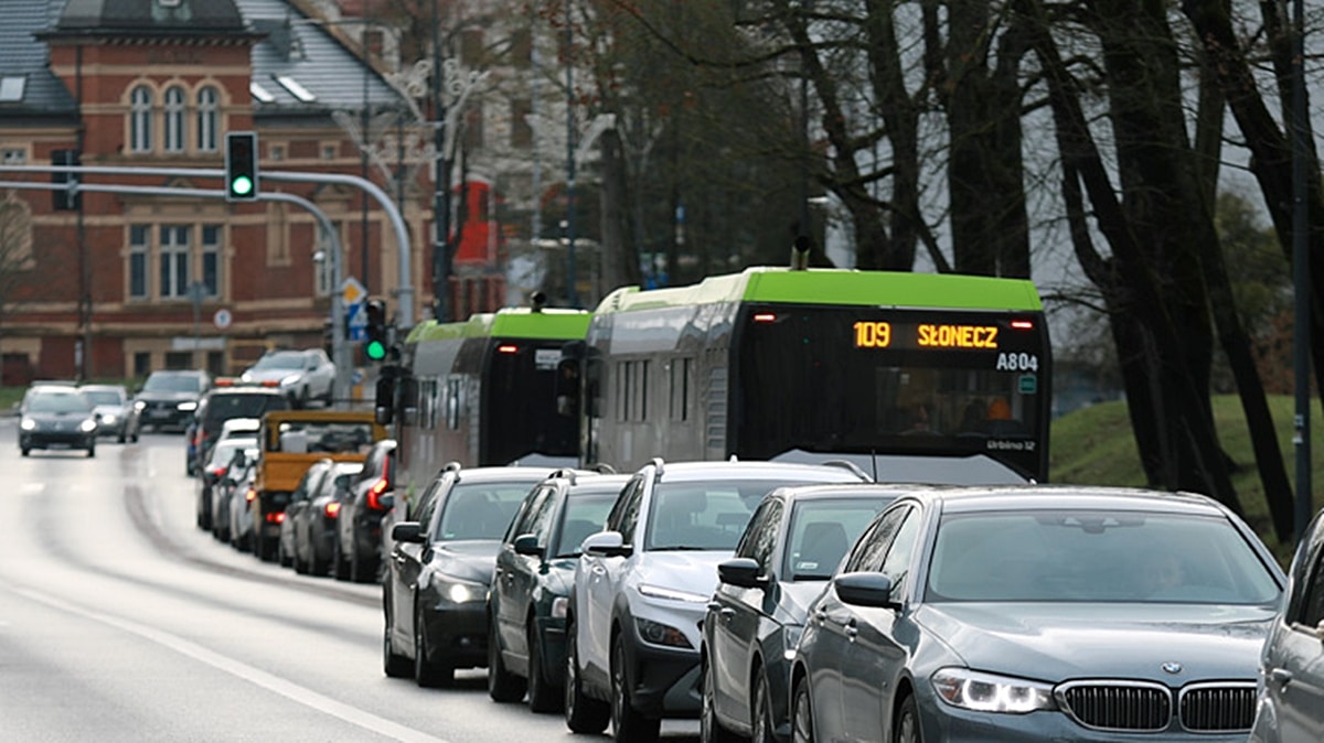 Korek samochodów na ulicy w Olsztynie, w tle autobus miejski.