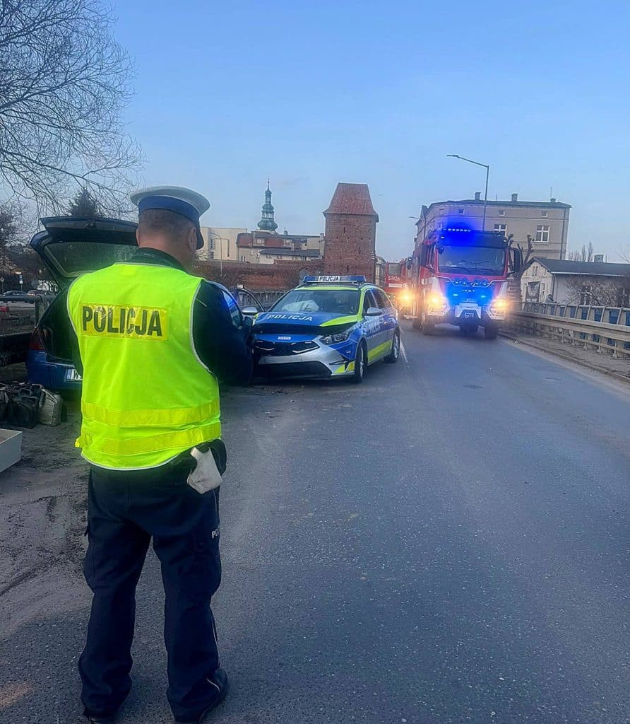 Policjant na miejscu wypadku, zderzenie auta z radiowozem na moście w Nowym Mieście Lubawskim.