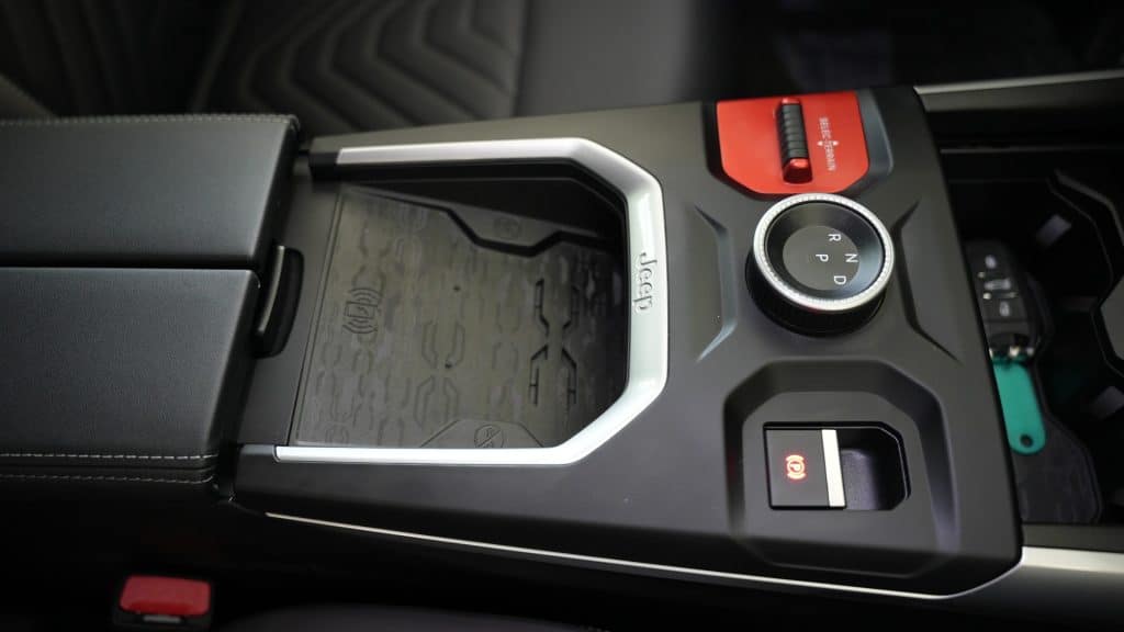 Widok na centralną konsolę nowego Jeepa Compassa w Olsztynie, z widocznym pokrętłem do zmiany bieg&oacute;w i ekranem dotykowym.