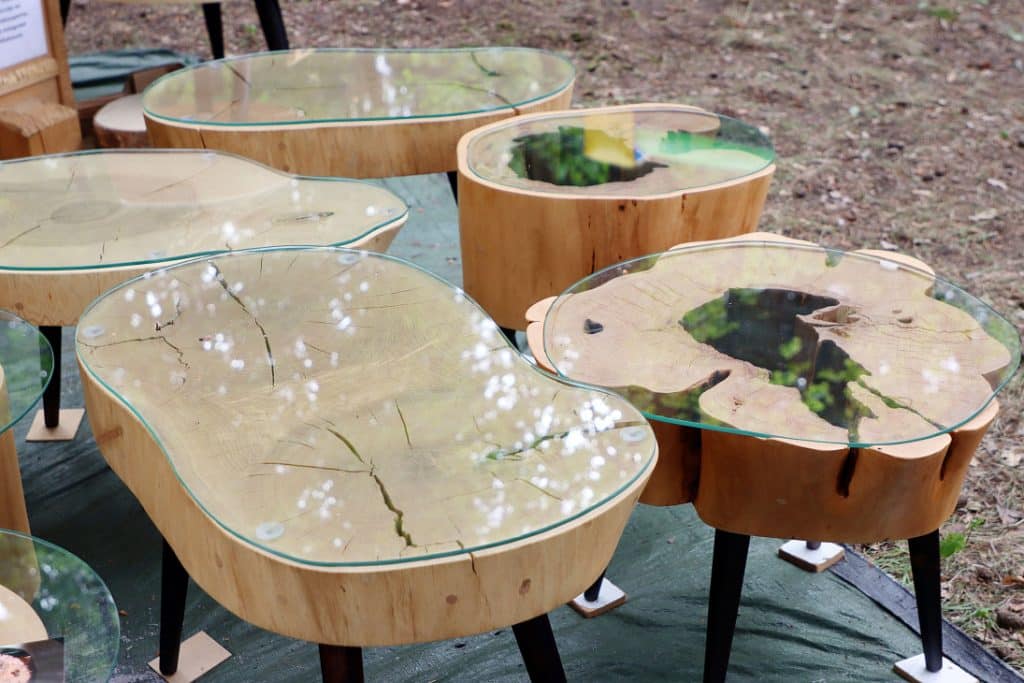 Stolik z naturalnego drewna z szklanym blatem na targach ogrodniczych.