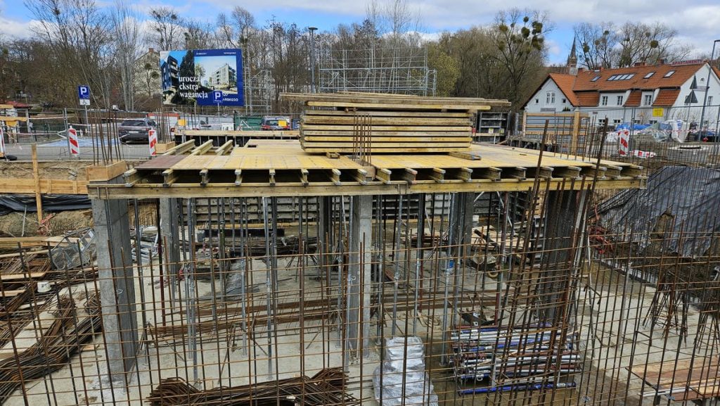 Budowa nowego obiektu hotelowo-gastronomicznego w centrum Olsztyna, widoczne prace i elementy konstrukcyjne.