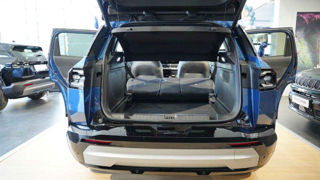 Nowy Jeep Compass w salonie, otwarty bagażnik ukazujący przestrzeń i pojemność.