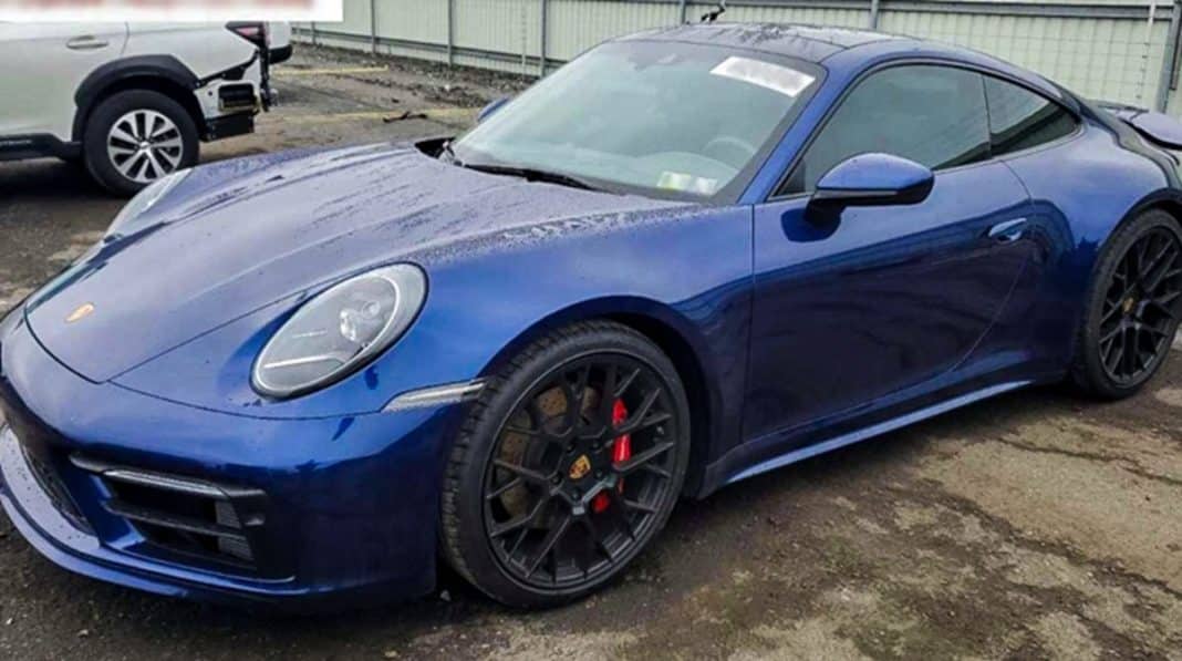 Niebieskie Porsche na parkingu, odzyskane po kradzieży, widoczne na zdjęciu.