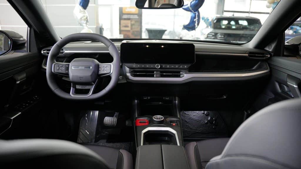 Wnętrze nowego Jeepa Compassa, widok z perspektywy kierowcy, nowoczesny panel i ekran dotykowy.