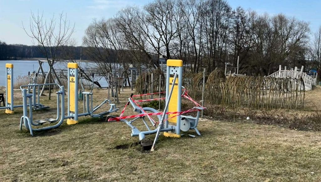 Zniszczone urządzenia plenerowej siłowni po wypadku samochodowego w Iławie.