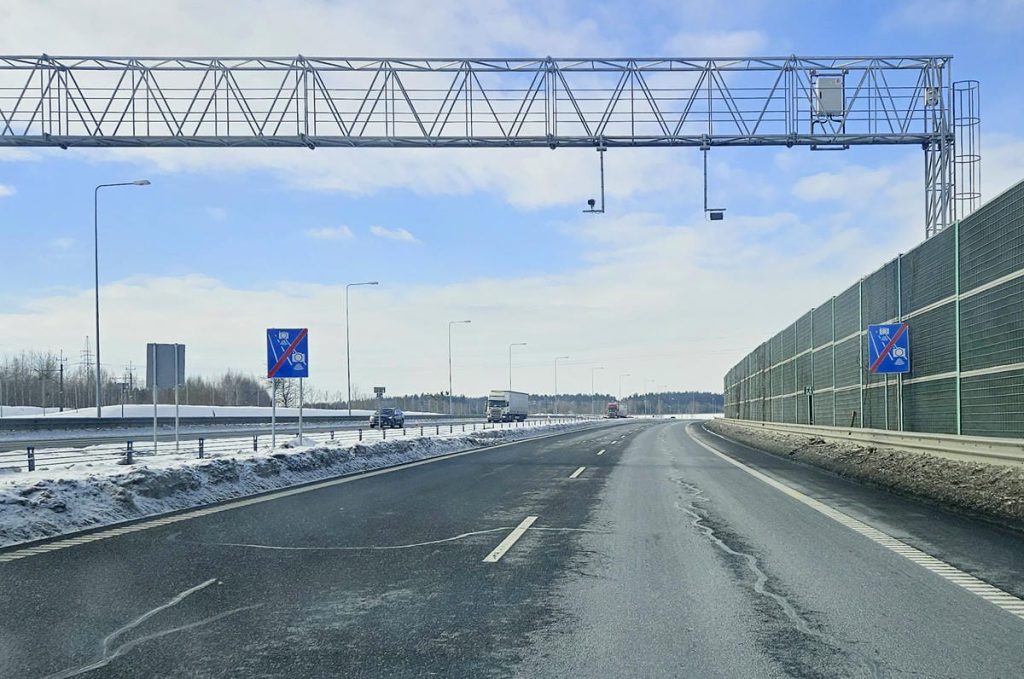 Zdjęcie odcinkowego pomiaru prędkości na trasie S51 pod Olsztynem, z oznakowaniem i słupami nad drogą.