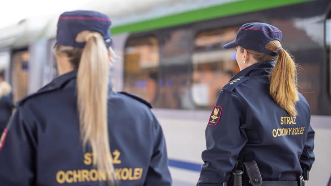 Dwie funkcjonariuszki Straży Ochrony Kolei na peronie, patrzą na biegającego mężczyznę z siekierą w tle.