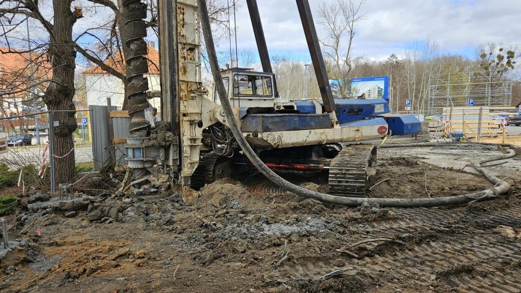 Budowa nowego obiektu hotelowo-gastronomicznego w centrum Olsztyna, widok na wykopy i maszyny budowlane.
