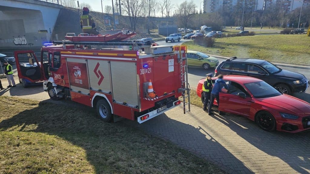 Samoch&oacute;d wywr&oacute;cony na rondzie w Olsztynie, służby ratunkowe na miejscu zdarzenia.