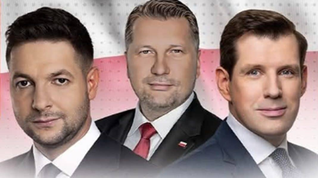 Zdjęcie trzech mężczyzn w garniturach, na tle r&oacute;żowo-białej tapety.