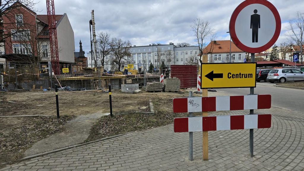 Budowa nowego obiektu hotelowo-gastronomicznego w centrum Olsztyna, widoczne wykopy i prace budowlane.