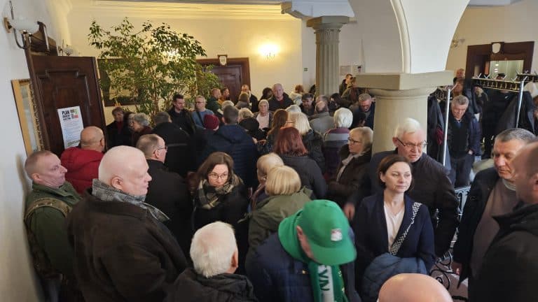 Tłum ludzi na spotkaniu w budynku, dyskusja o przyszłości ogrod&oacute;w działkowych.