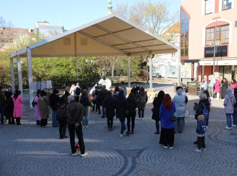 Uczestnicy zgromadzeni na Targu Rybnym podczas wydarzenia upamiętniającego Łukasza Litewkę, przynoszą karmę dla zwierząt.