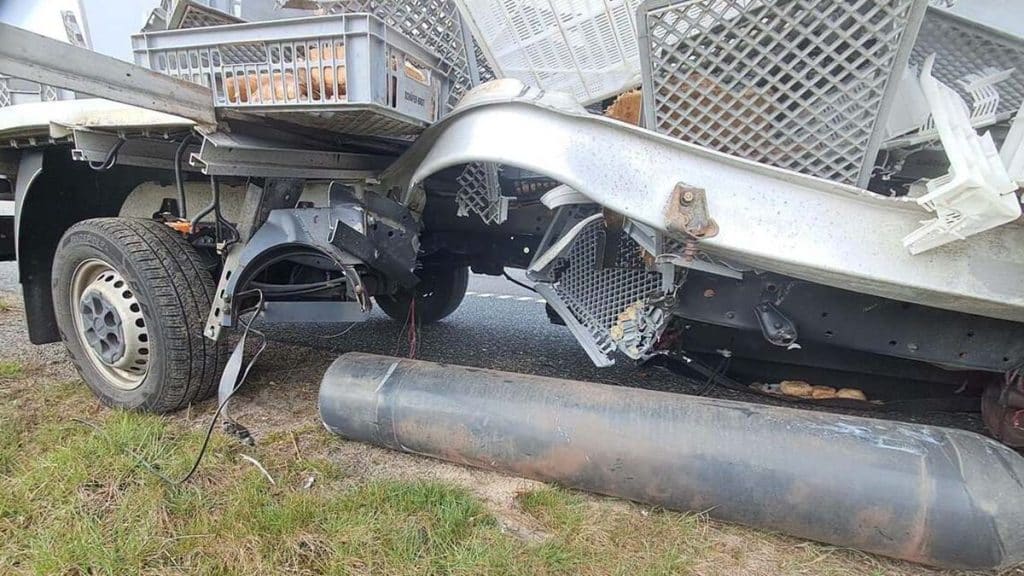 Uszkodzony samoch&oacute;d dostawczy po wybuchu na drodze S7, z rozsypanym ładunkiem na jezdni.