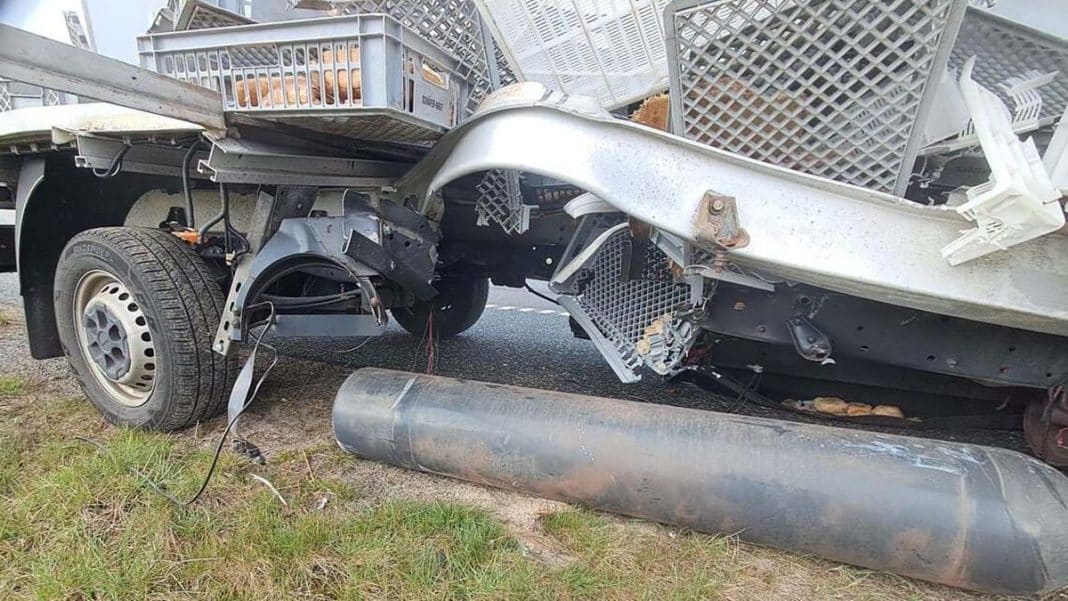 Uszkodzony samoch&oacute;d dostawczy po wybuchu na drodze S7, z rozsypanym ładunkiem na jezdni.