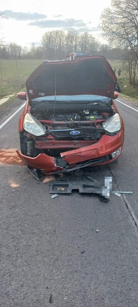Uszkodzony samoch&oacute;d z wbitym w prz&oacute;d motocykl, na drodze krajowej DK16.