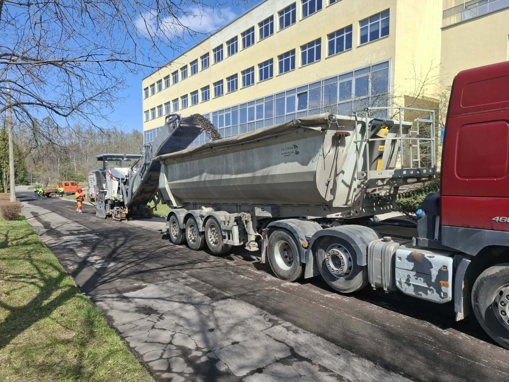 Prace remontowe na ulicy Kurta Obitza w Olsztynie, widok na ciężar&oacute;wkę i maszyny drogowc&oacute;w.