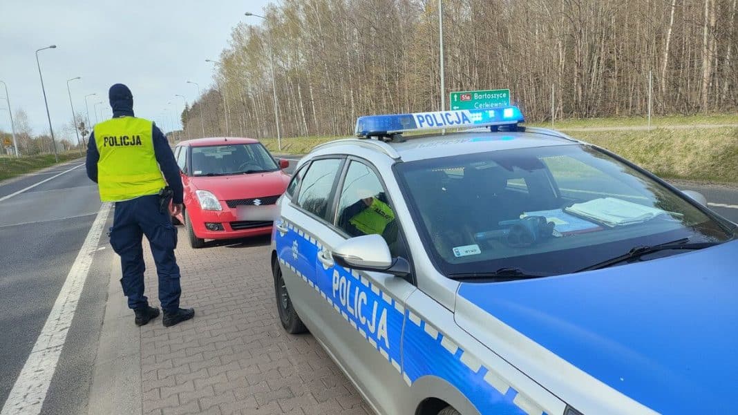 Policjant zatrzymuje kierowcę podczas kontroli na drodze krajowej pod Olsztynem.