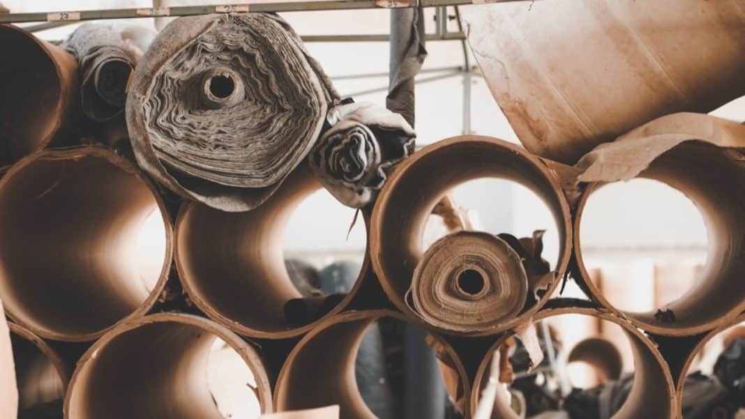 Rolka papieru i kartonowe tuby w magazynie opakowań ekologicznych.