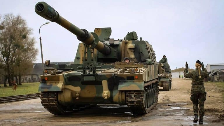 Armatohaubica K9 Thunder na placu wojskowym na Warmii, w tle żołnierz i jednostka wojskowa.