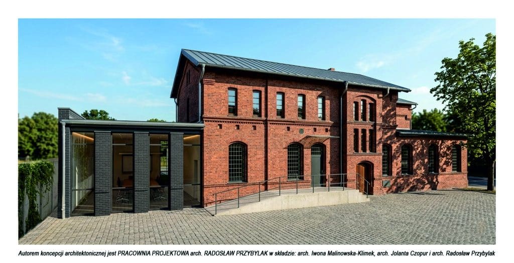 Widok odrestaurowanej części zabytkowych koszar Dragon&oacute;w z nowoczesnym dobud&oacute;wką, otoczony zielenią.