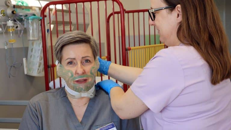 Pacjentka podczas przygotowań do operacji twarzy w szpitalu, z maską chłodzącą na twarzy.