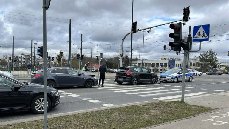 Kolizja dw&oacute;ch samochod&oacute;w na ruchliwym skrzyżowaniu w Olsztynie, obecność policji i utrudnienia w ruchu.
