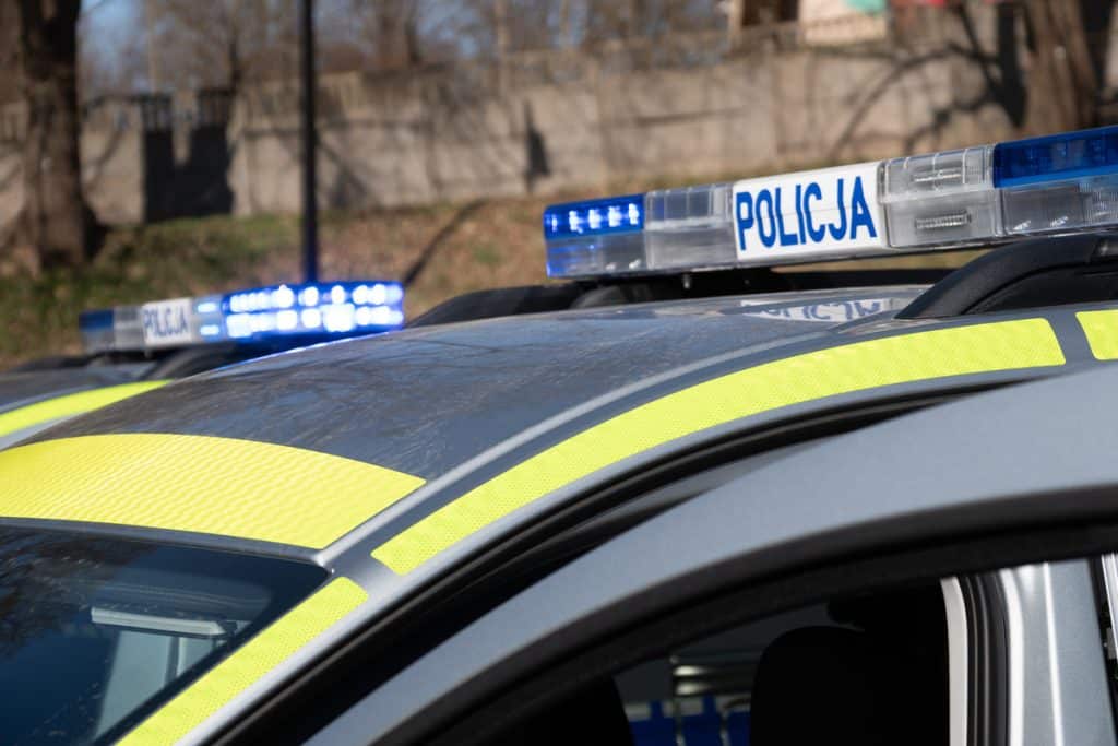 Nowe policyjne radiowozy na Mazurach, widoczne z bliska, z niebieskimi światłami i oznaczeniem POLICJA.