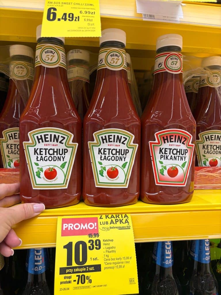 Butelki ketchupu Heinz na p&oacute;łce w sklepie, promocja na zakup dw&oacute;ch sztuk.
