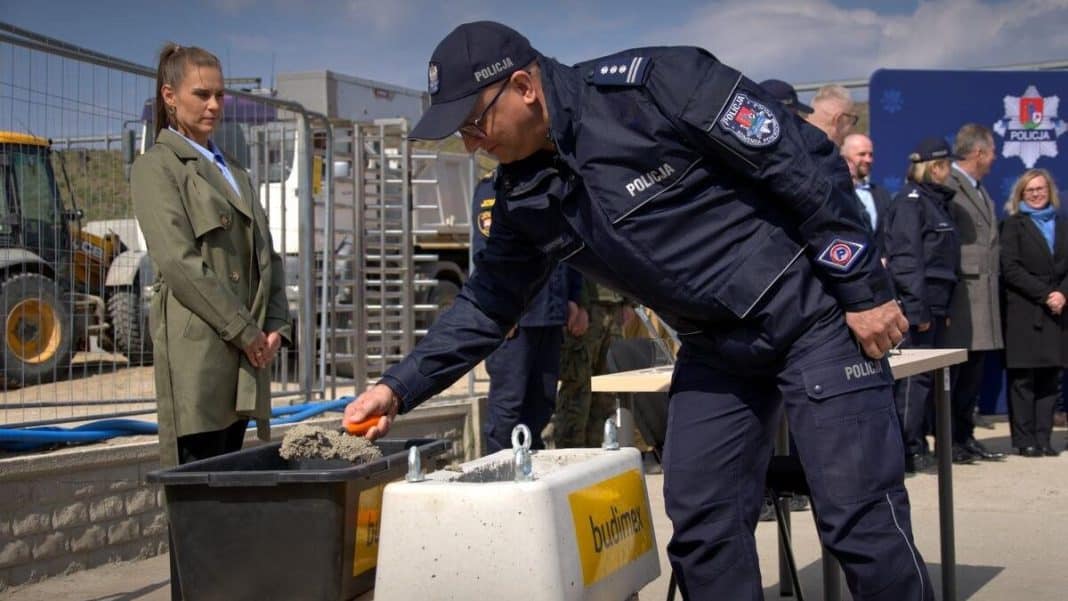 Policjant w uniformie podczas symbolicznego rozpoczęcia budowy nowej komendy w Ostr&oacute;dzie.