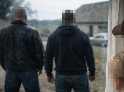 Rodzina rolnik&oacute;w obserwuje wprowadzenie się obcych mężczyzn do ich domu, scena z zewnątrz.