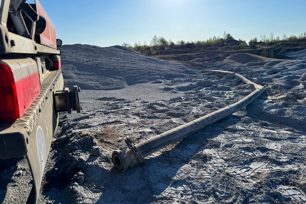 Zdjęcie przedstawia teren po akcji służb, z widoczną rurą i pojazdem na tle nieba.