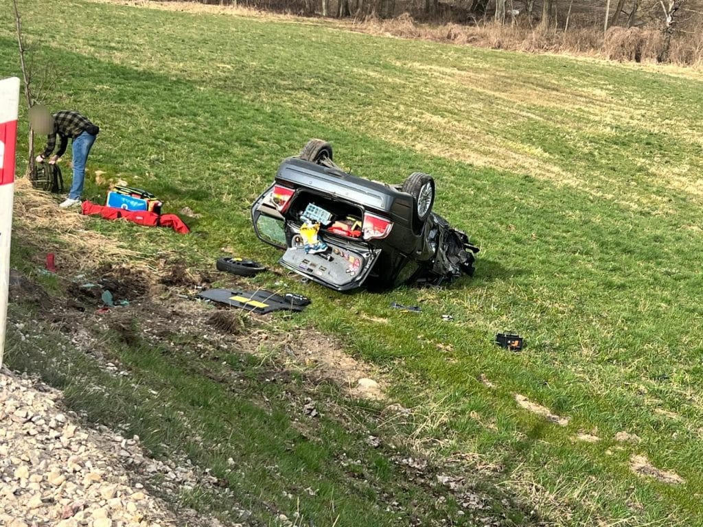 Wypadek na drodze krajowej nr 63 w miejscowości Ruda, samochody przewr&oacute;cone na poboczu, służby ratunkowe na miejscu.